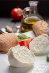 Traditional italian food - white ball mozzarella buffalo Italian soft cheese with cheese knife, tomato, basil, olive oil