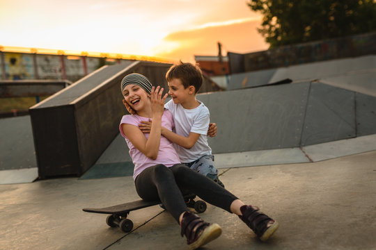 brother and sister having fun at skate park