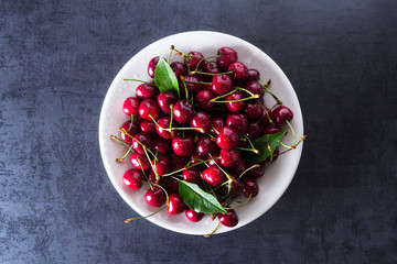 Fresh red ripe cherries on white plate