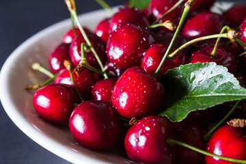 Fresh red ripe cherries on white plate