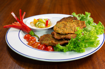 Fried fish mix spicy curry paste (Thai call Tod mun pla krai) eating with sauce pickles vegetables delicious thai food