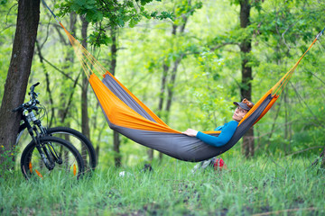 Woman relaxes in a hammock after biking
