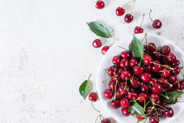 Fresh red ripe cherries on white plate