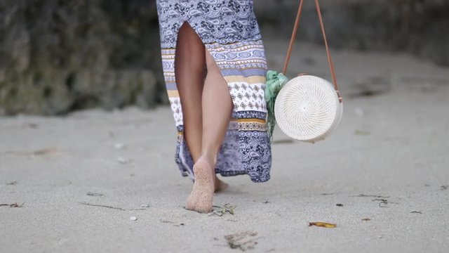 Woman with fashionable stylish rattan bag on the beach. Tropical island of Bali. Handmade Rattan eco handbag HD footage.