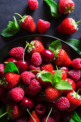 Fresh red ripe berries on black plate