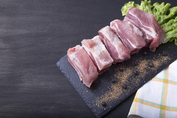 Raw uncooked pork ribs on dark wooden background. Top view