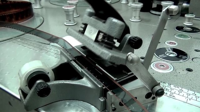 Man Prepare to cuts an old movie film on the machine