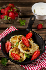Fried cottage cheese quark pancakes served with strawberries
