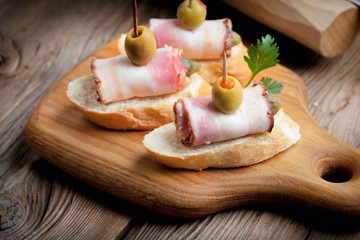 Tapas with sliced sausage, salami, olives and parsley.