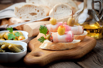 Tapas with sliced sausage, salami, olives and parsley.
