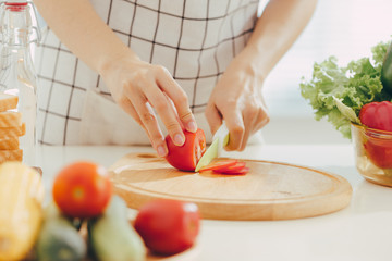 Young woman cutting vegetables in kitchen