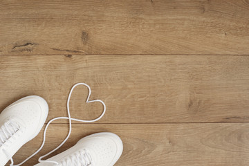 White Fashion Trendy Trainers with Heart. Love, Hipster Set. Female sneakers, sport shoes in flat lay style, top view. Fitness concept, active lifestyle, body care concept