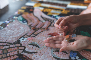 Female hands with mosaic - obrazy, fototapety, plakaty