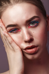 Fototapeta na wymiar Beauty portrait of young woman with colorful make-up. Blue eyelashes and pink eyeliner