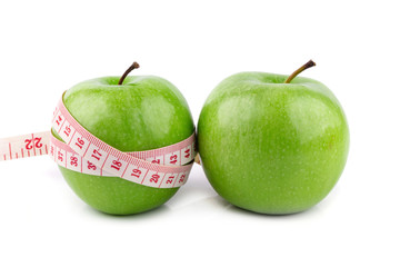 Fresh green apples and white tape measuring isolated on white background.  Healthy fruit concept