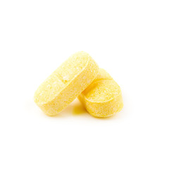Vitamin C, yellow vitamin pills isolated on white background.