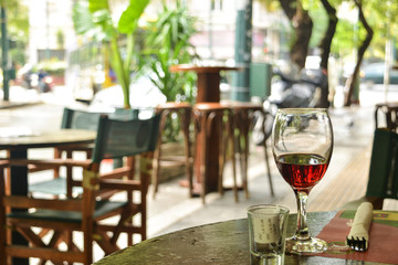 The glass of red wine standing on a table of street cafe