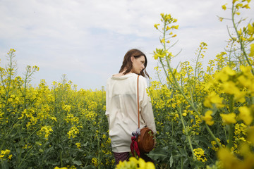 Fototapeta premium Portrait of fashionable young woman in the yellow flowers field 