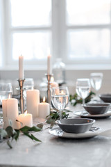 Wedding or festive table setting. Plates, wine glasses, candles and cutlery