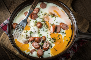 Tasty cooked egg with chopped sausages.