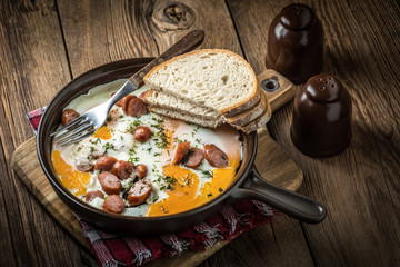 Tasty cooked egg with chopped sausages.