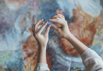 Female hands with a mosaic