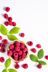 Fresh raspberries in wooden bowl on white table.  © nadianb