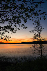 Sunset over lake and trees.Poland, Masuria.