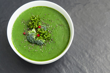 Spinach green soup with broccoli in white bowl top view
