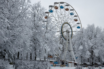 Winter morning in the park. Ferris wheel in winter. Consequences of snow