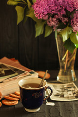 A cup of hot tea and a bouquet of lilac flowers (a date)  Food background