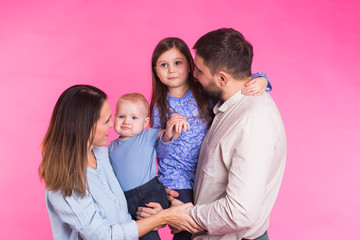 Happy mixed race family portrait smiling on pink background