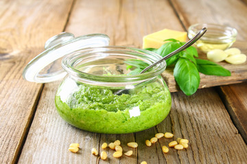Homemade pesto sauce. Ingredients. Cheese, garlic, basil, pine nuts, olive oil on an old wooden table.