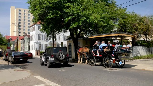CHARLESTON, SC - APRIL 7, 2018: Tourists on a horse carriage make a city tour. The city attracts 15 million people annually