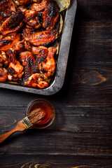 chicken wings of barbecue in honey sauce with lime slices. the dish is made and served in a rustic style