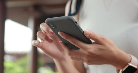 Close up of woman using mobile phone in Chinese garden