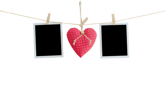 Blank instant photos and red heart hanging on isolated white with clipping path.