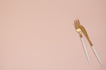 Gold cutlery. Golden spoon set, golden knife and fork on the table. Luxury spoon set top of view....