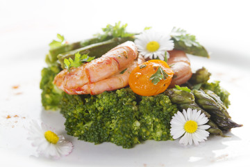 Prawns, asparagus and broccoli with edible daisy flowers. Selective focus.