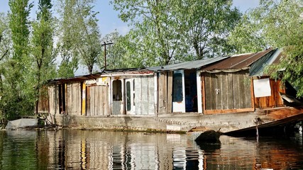 Fototapeta na wymiar Hausboote und Häuser im Dal See in Kashmir, Indien