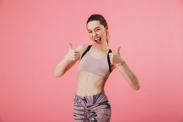 Cheerful sportswoman showing thumbs up and looking at the camera