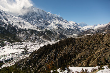 On the Annapurna circuit trekking trail between Upper Pisang village and Ngawal village on a sunny day in the Himalayas in Nepal