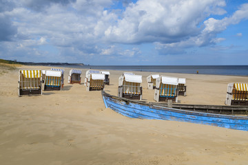 Verlassene Strandkörbe mit blauem Boot an der Ostsee