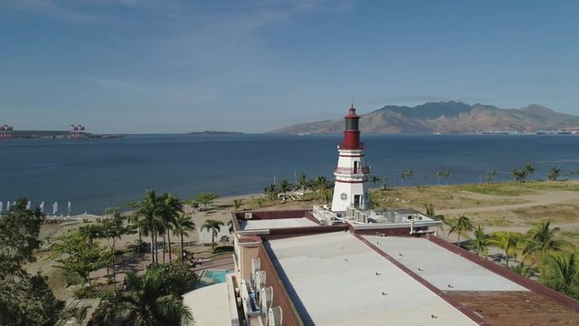 Coastline with beach and lighthouse, mountains. Aerial view: Coast sea with hotels, resorts, Subic Bay, Philippines, Luzon