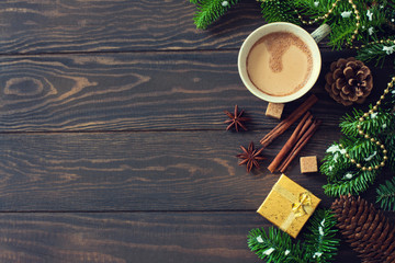 Christmas wood background with fir branches, fir-cones, cup of coffee and gift boxes