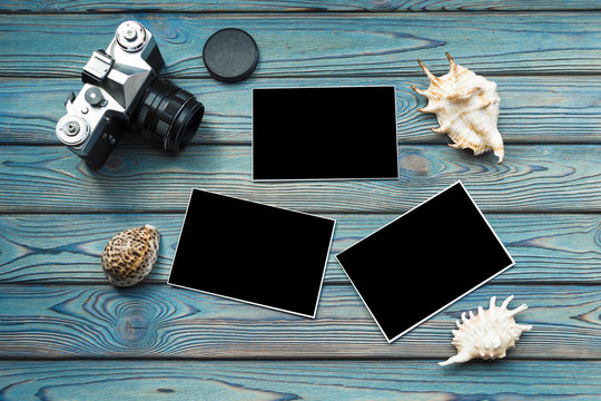 camera, seashells, photos with black filling, on a wooden background of blue color. travel, cruise.