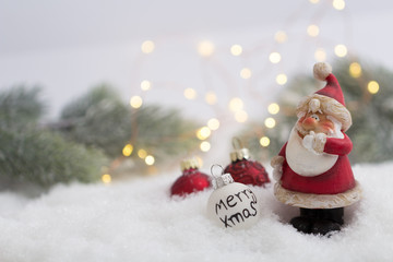 Weihnachtsmann steht im Schnee mit Christbaumschmuck