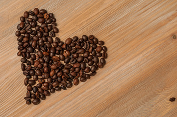 bright cup with coffee beans and sweets on a wooden table