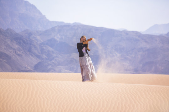 Woman standing on a sand dune in the desert of Jordan