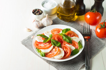 Close-up photo of caprese salad with ripe tomatoes, basil, buffalo mozzarella cheese. Italian and Mediterranean food concept. Fresh and healthy organic meal. Starter and antipasti. 